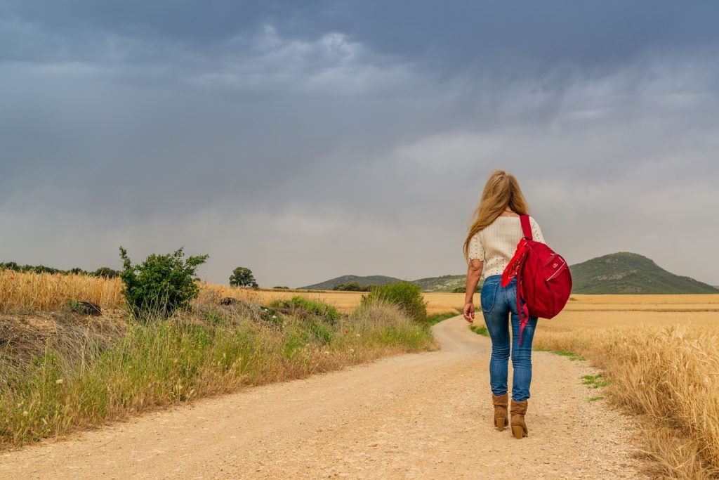 A girl walking down a country road.